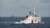 FILE - A Chinese Coast Guard vessel, with the disputed oil rig in the background, is seen in the South China Sea, June 13, 2014.