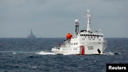 FILE - A Chinese Coast Guard vessel, with the disputed oil rig in the background.