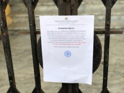 Surat pemberitahuan penutupan sementara Istana Maimun di Kota Medan dipasang di pagar istana, Rabu, 18 Maret 2020. (Foto: Anugrah Andriansyah/VOA)