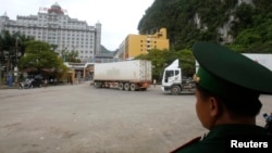 Seorang petugas mengawasi truk-truk yang melintasi gerbang perbatasan Tan Thanh antara Vietnam dan China. 