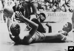 Indiana State's Larry Bird, left, lies on his back to toss the ball during a scramble with Earvin "Magic" Johnson, right, during NCAA Championship game in Salt Lake City, Utah, March 26, 1979. (AP Photo)