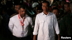 Tổng thống Indonesia Joko Widodo (phải) và Tổng giám đốc AirAsia Tony Fernandes rời khỏi địa điểm sau khi gặp thân nhân các hành khách trên chuyến bay AirAsia bị lâm nạn, tại sân bay quốc tế Juanda, Indonesia 30/12/13