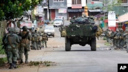 FILE - Philippine marines walk to the frontline during operations aimed at wresting control of Marawi city from militants linked to the Islamic State group, May 28, 2017, in southern Philippines.
