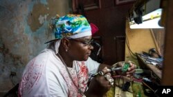 Teknisi perhiasan dan elektronik Gabriel La O memperbaiki sebuah ponsel di dalam toko pemerintah yang ia sewa di Havana, Kuba (24/5). (AP/Desmond Boylan)