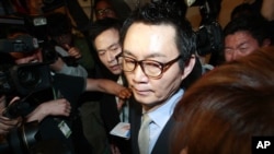 South Korean President Park Geun-hye's spokesman Yoon Chang-jung surrounded by journalists leaves after a press conference in Seoul, South Korea, May 11, 2013. 