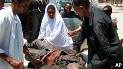 Residents assist a civilian wounded in a crossfire during fighting between government soldiers and Islamist rebels in Hodan district, northern Mogadishu, March 13, 2011