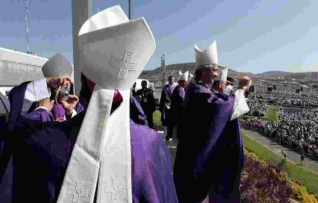 Prelados católicos toman fotografías en el Parque del Bicentenario donde el papa dio una misa campal. (AP)