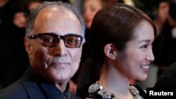 FILE - Director Abbas Kiarostami (L) and cast member Rin Takanashi arrive on the red carpet for the screening of the film "Like Someone in Love", in competition at the 65th Cannes Film Festival, May 21, 2012. 