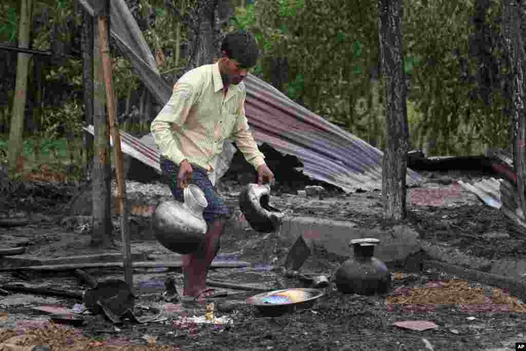 A villager salvages utensils from a burnt house after the area was set on fire in ethnic violence at Khagrabari village, in the northeastern Indian state of Assam.