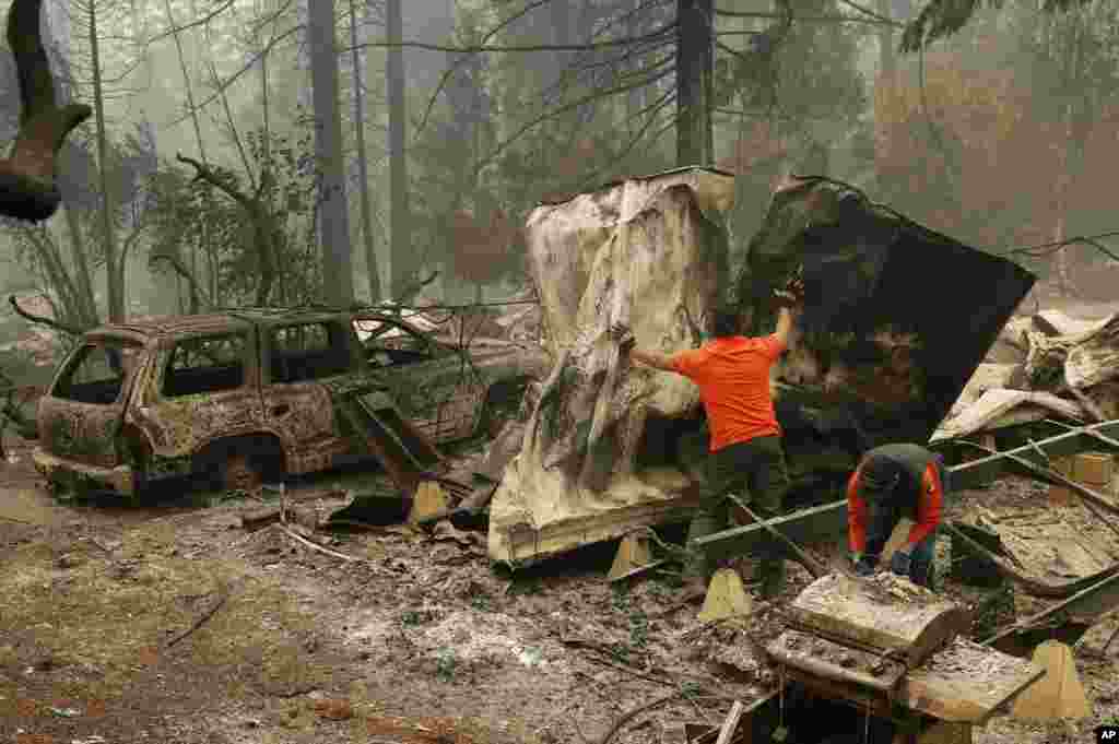 Rescue workers search for human remains at a burned out trailer park from the Camp fire, Nov. 13, 2018, in Paradise, California.