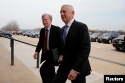 FILE - Secretary of Defense James Mattis greets John Bolton, left, as he arrives at the Pentagon in Washington, March 29, 2018.