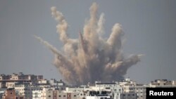 Asap dan pasir membubung ke udara menyusul serangan udara Israel di Gaza (25/8). (Reuters/Ahmed Zakot)