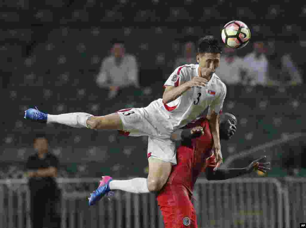 13일 홍콩에서 열린 아시아축구연맹(AFC) 주최 '2019 아시안컵' 예선전에서 북한의 김유성 선수가 홍콩 선수와 공을 다투며 헤딩을 하고 있다.
