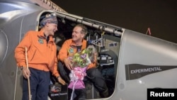 Pilot Andre Boschberg (R) chats with pilot Bertrand Piccard after Boschberg landed "Solar Impulse 2" in Muscat, Oman, March 9, 2015. 