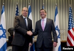 U.S. Secretary of Defense Ash Carter (R) and Israel's Defense Minister Moshe Yaalon shake hands during their meeting at the Kirya base in Tel Aviv, Israel, July 20, 2015.