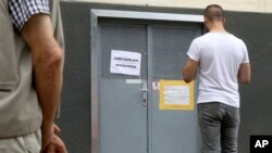 Quelques personnes devant une mosquée fermée à Vienne, en Autriche, le 8 juin 2018. La mosquée est l'une des sept dont le gouvernement autrichien a annoncé la fermeture. 