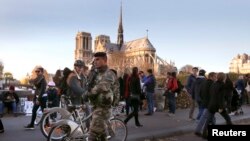 FILe - A soldier patrols on a bridge near Notre Dame cathedral following deadly attacks in Paris, Nov. 15, 2015. 