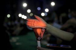 An activist holds a candle during a vigil for the victims of the 1989 Tiananmen Square Massacre, despite permission for the gathering being officially denied, at Victoria Park in Causeway Bay, Hong Kong.