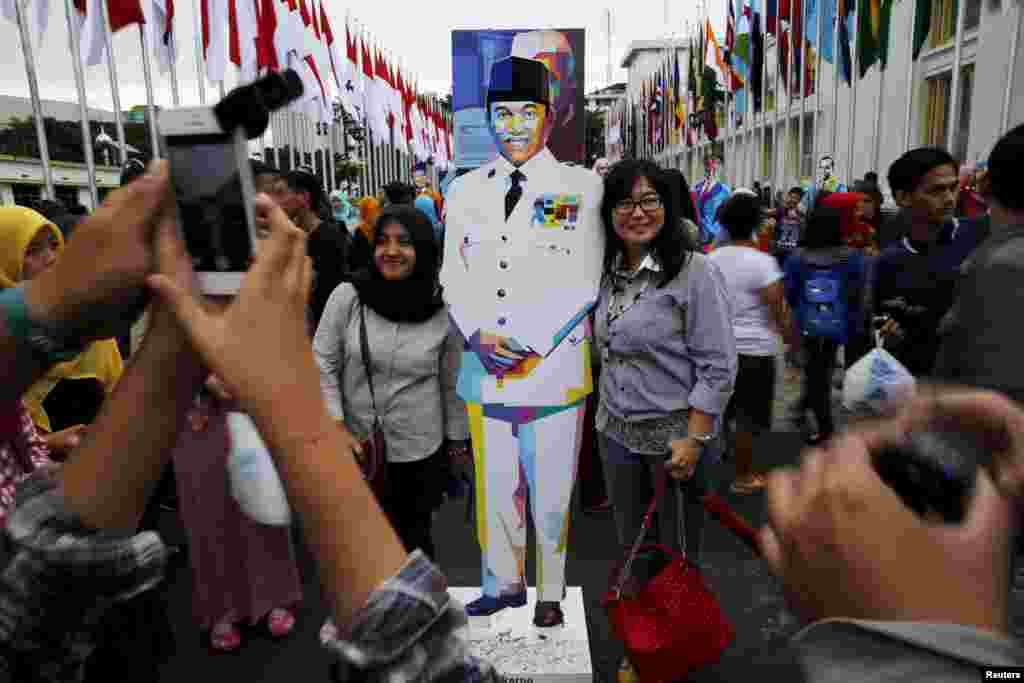 Watu wapiga picha pamoja na sanamu ya rais wa kwanza wa Indonesia, Bw.Soekarno mjini Bandung, Indonesia, mtu aliyesukuma kuanzishwa kwa uhusiano huo wa kihistoria. April 24, 2015.