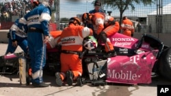 Esfuerzo por rescatar a Darío Franchitti, de su auto luego de chocar contra una barrera en el Gran Premio Indy de Houston.