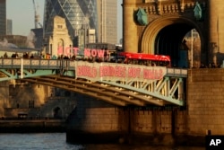 Campaigners hold a banner reading "Build Bridges Not Walls" from Tower Bridge in London to protest Donald Trump's inauguration as U.S. president, Jan. 20, 2017.