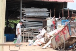 Mao Tran surveys piles of scraps stored at a rented warehouse in Phnom Penh, Cambodia, April 22, 2020. (Phorn Bopha/VOA Khmer)