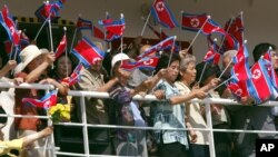 지난 2003년 1월 일본 니가타에서 북한 원산으로 출항하는 '만경봉-92' 호 승객들이 인공기를 흔들고 있다. 북한은 재일 한인 북송 사업에 이용한 만경봉 호가 노후하자, 1992년 '만경봉-92' 호를 건조했다.