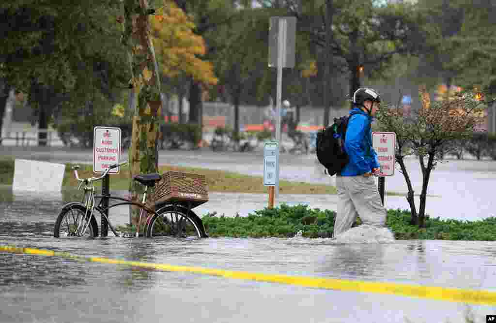 A Norfolk resident chains his bike and heads to work in floodwaters near downtown Norfolk, Virginia, Oct. 29, 2012. Rain and wind from Hurricane Sandy are hitting the area. 