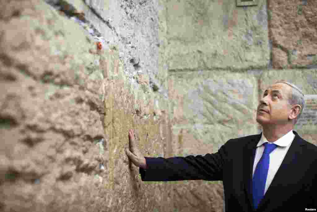 以色列总理内塔尼亚胡2013年1月22日在议会选举投票站投票之后，触摸耶路撒冷老城区的西墙。