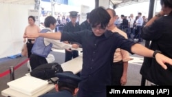 FILE - A volunteer gets a security check during a security drill for the 2020 Olympic Games in Tokyo Friday, Sept. 28, 2018. (AP Photo/Jim Armstrong)