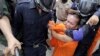 Cambodian police detain a Buddhist monk who was demonstrating for the release of seven convicted land-rights activists in Phnom Penh, Nov. 11, 2014.