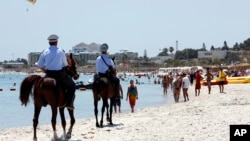 FILE - Mounted police officers patrol on the beach of Sousse, Tunisia, June 28, 2015. 