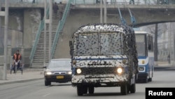 A bus covered in a net-like object drives on a street in Pyongyang, North Korea, in this photo taken by Kyodo, March 6, 2013. 