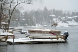 Perahu dan dermaga tertutup salju di Danau James akibat badai musim dingin di Morganton, North Carolina, Minggu, 16 Januari 2022. (AP/Kathy Kmonicek)