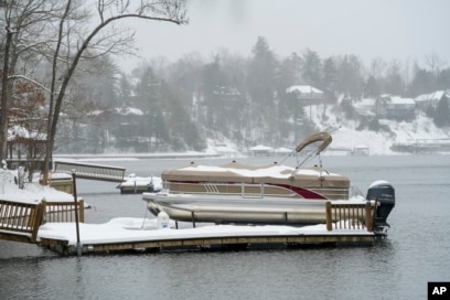 Perahu dan dermaga tertutup salju di Danau James akibat badai musim dingin di Morganton, North Carolina, Minggu, 16 Januari 2022. (AP/Kathy Kmonicek)