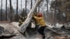 Firefighters move debris while recovering human remains from a trailer home destroyed by the Camp Fire in Paradise, California, U.S., Nov. 17, 2018. 