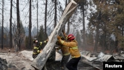 Los bomberos mueven escombros mientras recuperan restos humanos de un remolque destruido en Paradise, California, EE. UU., 17 de noviembre de 2018.