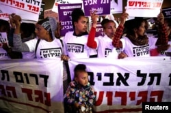 FILE - People take part in a protest against the Israeli government's plan to deport African migrants, in Tel Aviv, March 24, 2018.