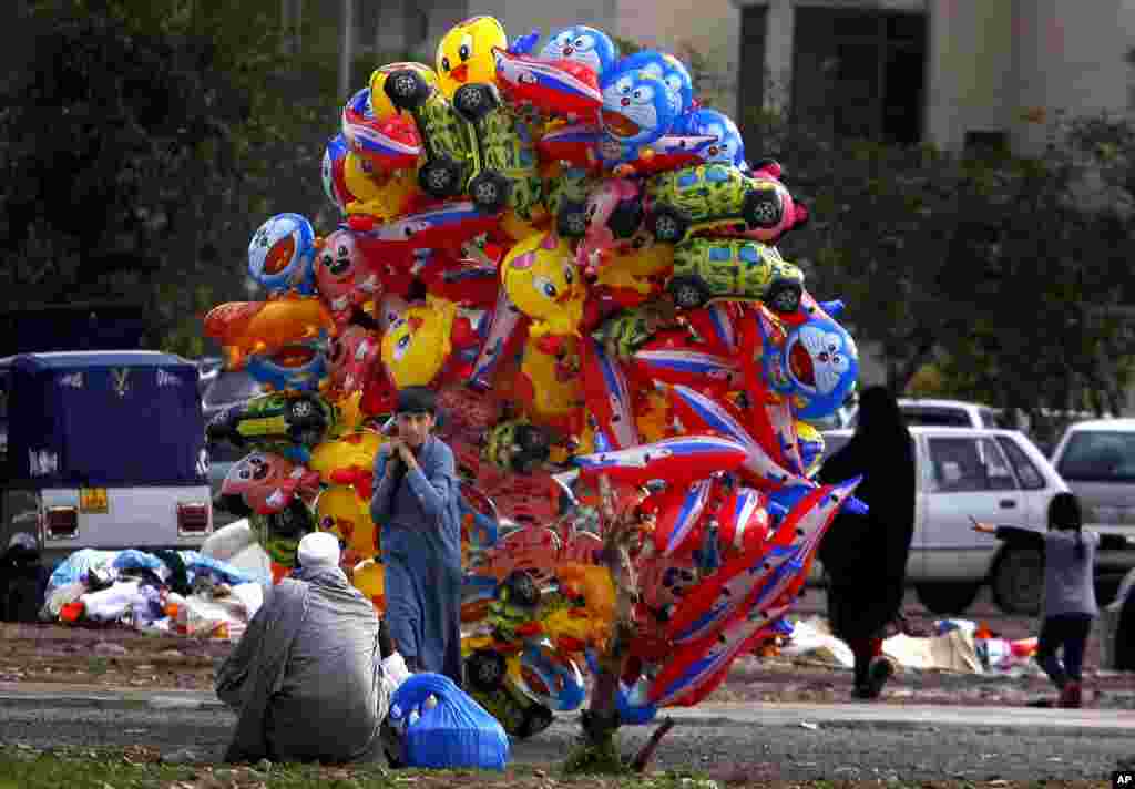 A boy sells balloons on a street in Peshawar, Pakistan.