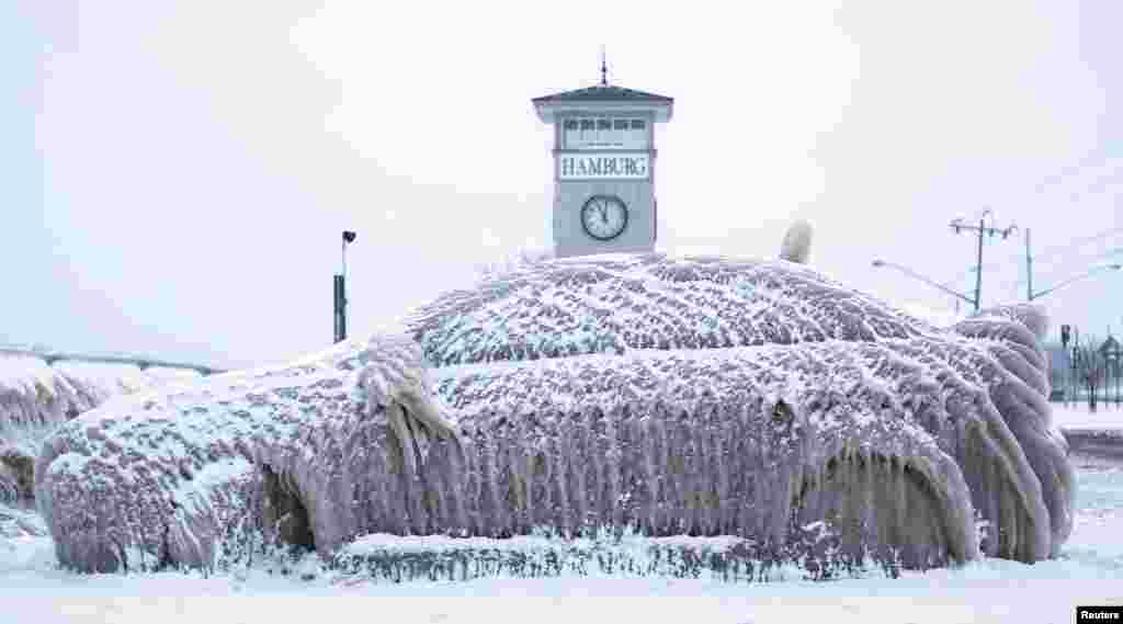 A car covered with ice remains stranded on the waterfront in Hamburg, New York, Jan. 12, 2016. The owner left his Mitsubushi Lancer parked overnight outside a restaurant on Sunday and the next day, spray from Lake Erie had encased it in ice.