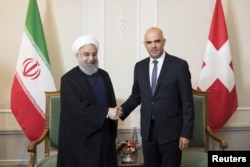 Swiss Federal President Alain Berset and Iranian President Hassan Rouhani shake hands at the beginning of a meeting during Rouhani's official visit to Switzerland in Bern, Switzerland, July 2, 2018.