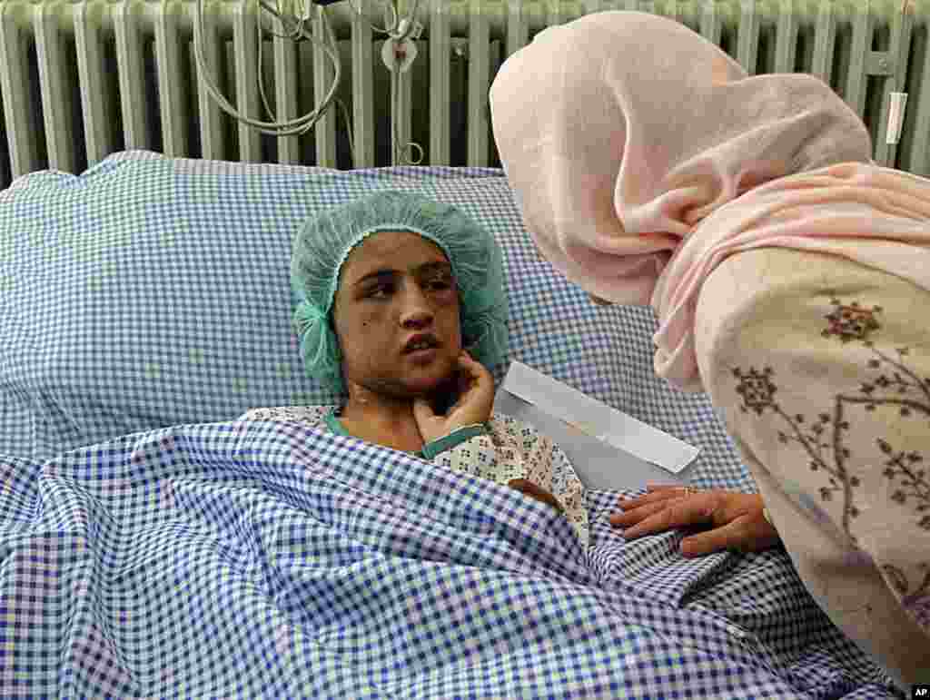 Afghanistan's caretaker Minister for Women's Affairs Dr. Husn Banu Ghazanfar visits an Afghan girl, who was tortured, beaten and locked in a toilet for months after refusing prostitution, as she lies on a hospital bed in Kabul December 31, 2011. Sahar Gul