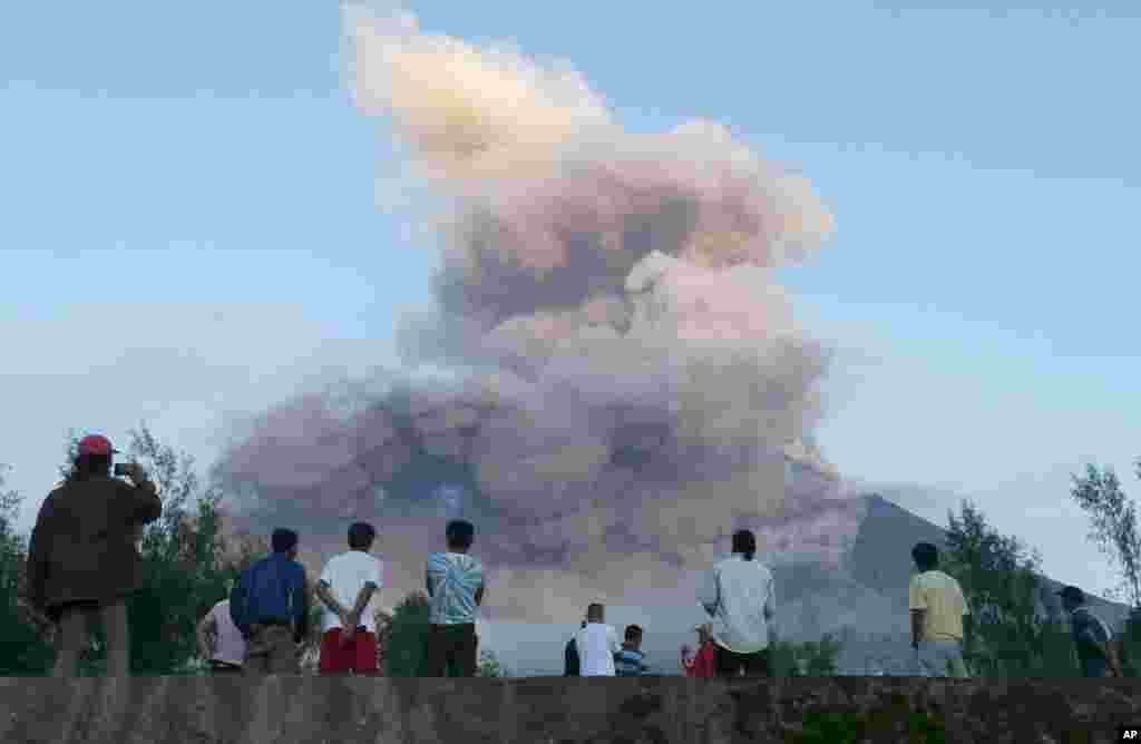 Residents watch from Legazpi city, Albay province, as Mayon volcano erupts, Jan. 24, 2018. Lava from the Philippines' most active volcano has flowed up to 3 kilometers (1.86 miles) from the crater in a dazzling eruption.