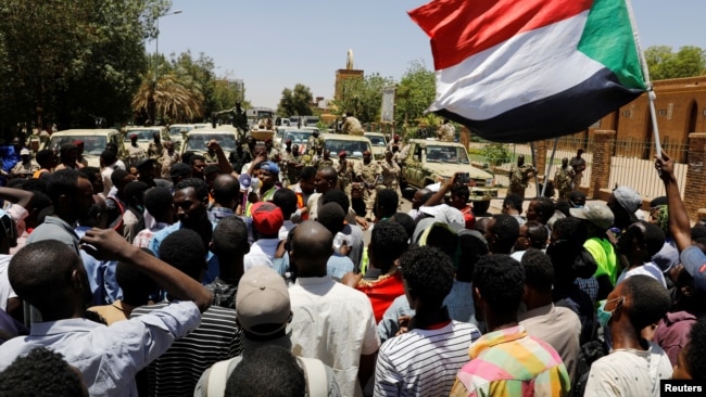 Sudanese demonstrators chant slogans in front of security forces during a protest in Khartoum, Sudan, Apr. 15, 2019. 