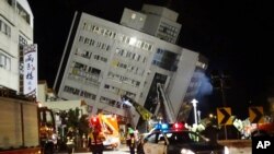 Rescuers are seen entering a building that collapsed onto its side from an early morning 6.4 magnitude earthquake in Hualien County, eastern Taiwan, Feb. 7 2018. Rescue workers are searching for any survivors trapped inside the building. 