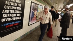 FILE - Cyrus McGoldrick, a member of the Council on American-Islamic Relations, talks to commuters as they walk by an advertisement that reads "Support Israel/Defeat Jihad" in the Times Square subway station in New York, Sept. 24, 2012.