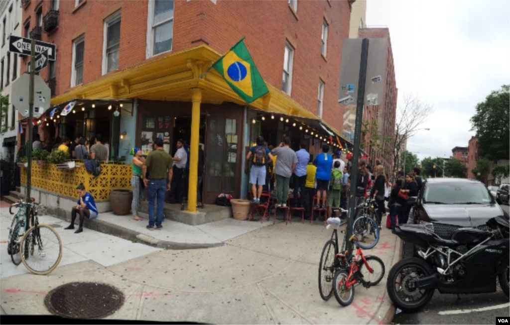 Para penggemar sepakbola antre untuk masuk klub Little Favela di Brooklyn, New York, untuk menonton Piala Dunia 2014 (12/6). (VOA/Adam Phillips)