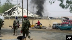 FILE - Nigerian soldiers patrol outside the site of an accidental explosion of Boko Haram bombs in Yola, Nigeria, Feb. 25, 2016. 