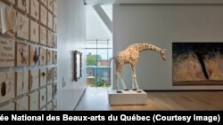 Part of Nadia Myre’s The Scar can be seen on the far left. In the center is Trevor Gould’s Nubian Giraffe. Through the window, visitors can look out onto Quebec’s Grand Allee and the city beyond.