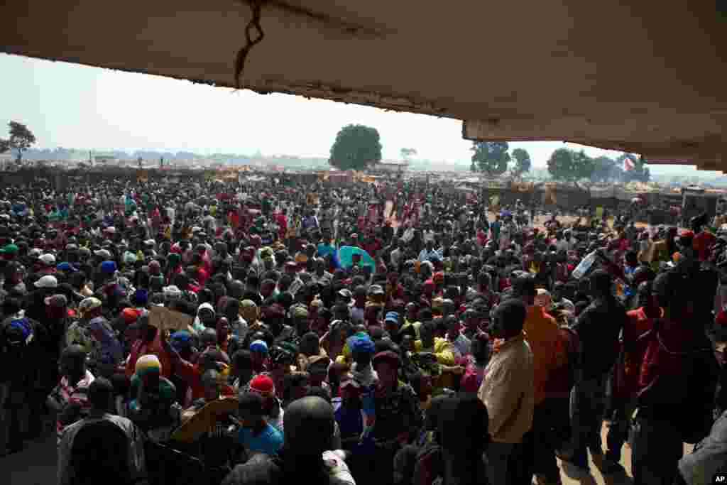 People wait to receive food and supplies from an aid distribution point set up inside a makeshift camp at Mpoko Airport in Bangui, Jan. 7, 2014. 